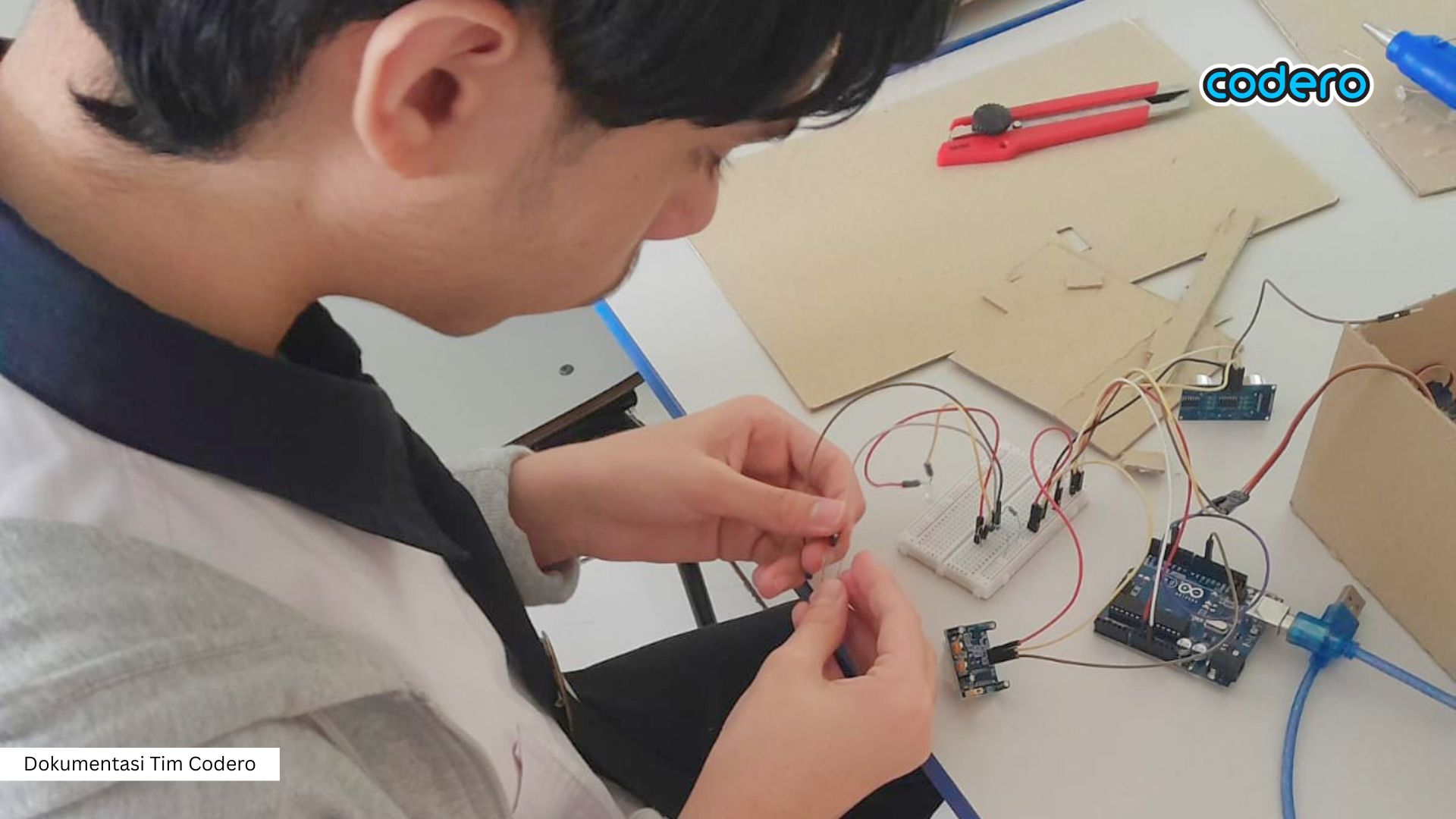 Anak-anak sedang belajar merakit proyek teknologi pintar IoT di kelas Codero