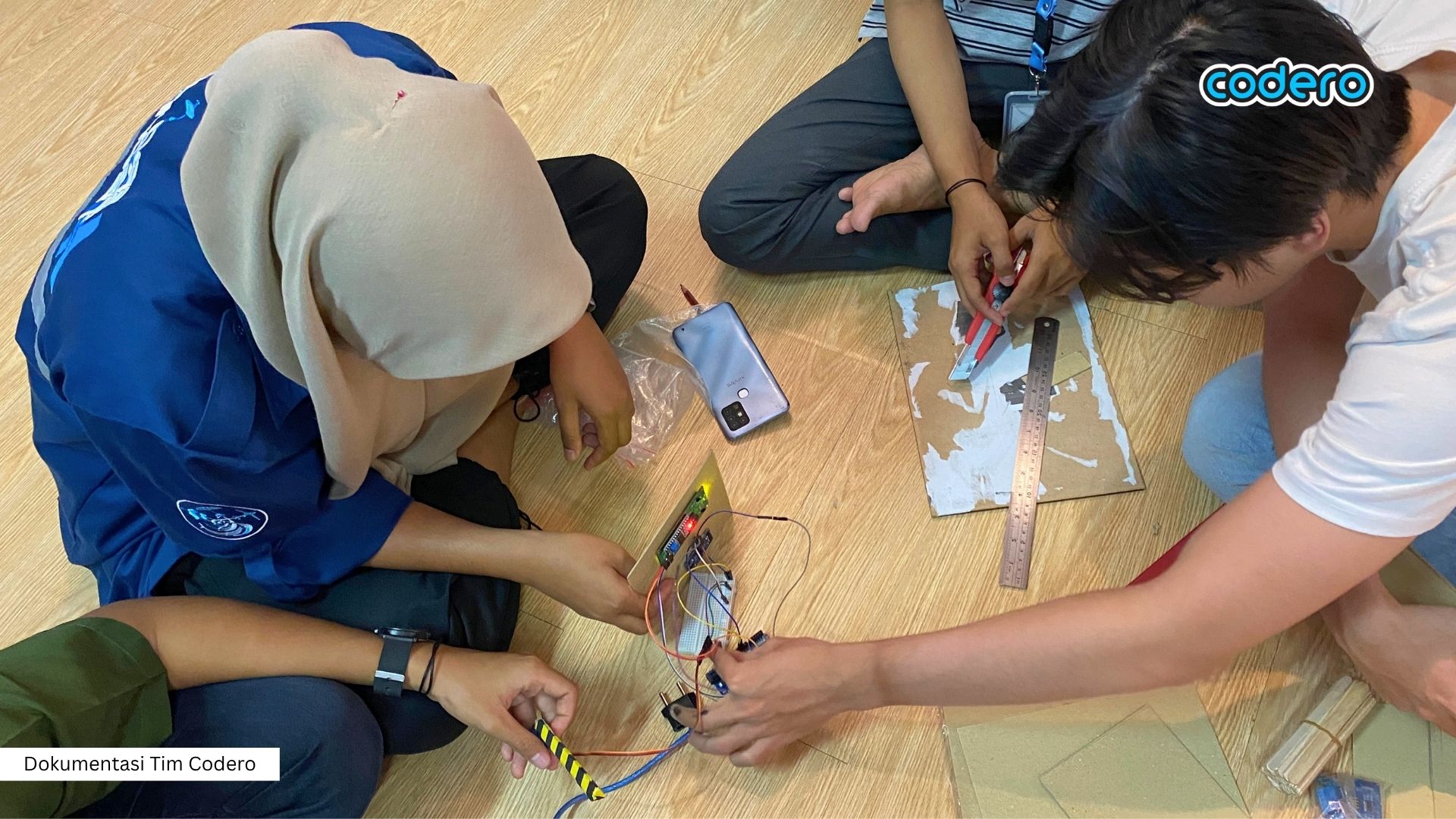Anak-anak sedang belajar merakit proyek teknologi pintar IoT di kelas Codero
